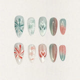 Ocean Reverie nail set combines aqua blues and coral pinks with wave patterns, soft floral motifs, and gradient fades, encapsulating the peaceful beauty of a coastal escape.