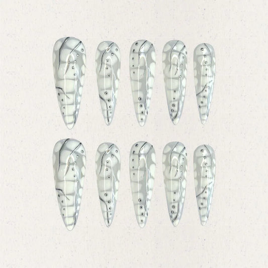 Cyber Shell nail set features a glossy metallic base with intricate linework and dot embellishments, resembling the exoskeleton of advanced technology. This design is a bold statement of modern elegance and innovation.