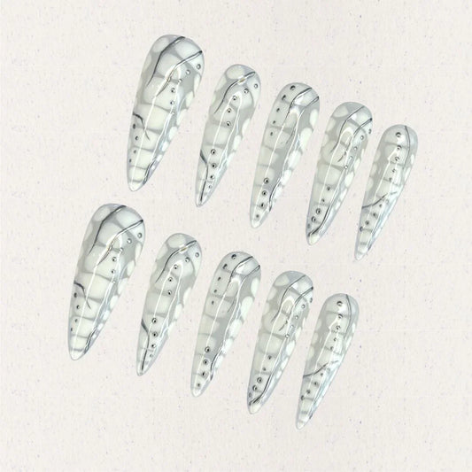 Cyber Shell nail set features a glossy metallic base with intricate linework and dot embellishments, resembling the exoskeleton of advanced technology. This design is a bold statement of modern elegance and innovation.