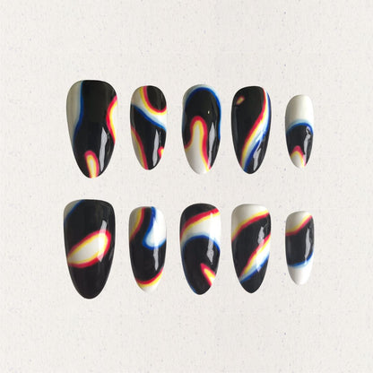 Press-on nails featuring abstract swirls in black, white, red, yellow, and blue, evoking a modern and cosmic aesthetic.