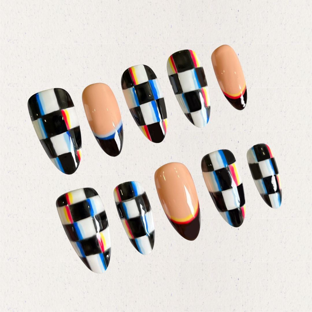 Press-on nails with bold checkered patterns in black, white, and colorful stripes, blending modern and retro vibes.