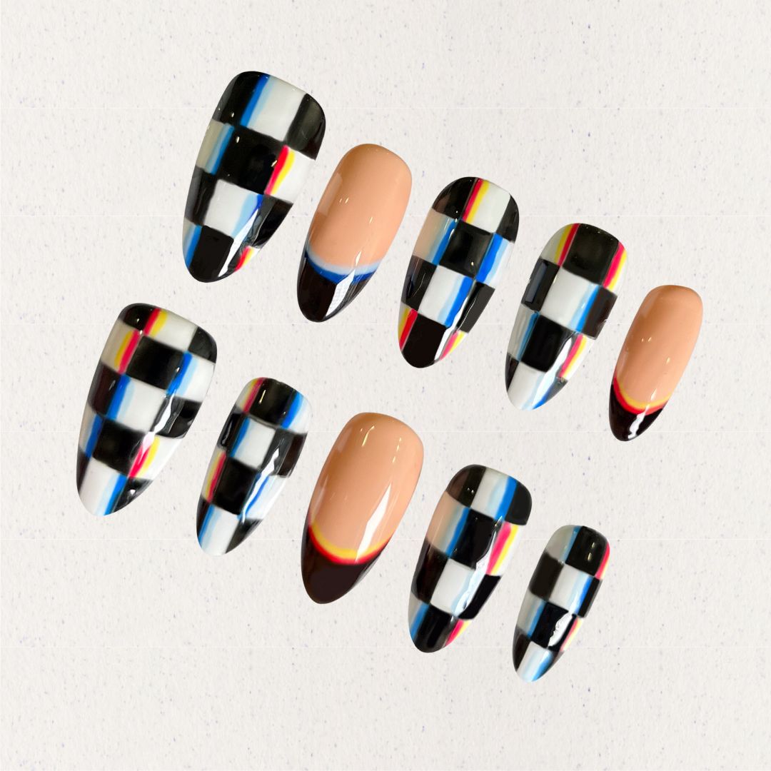 Press-on nails with bold checkered patterns in black, white, and colorful stripes, blending modern and retro vibes.