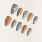 Radiant Spiral nails showcase vivid gradient shades of orange and pink, with circular patterns and shimmering accents, exuding energy and vibrancy.
