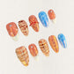 Fiery Glow press-on nails showcasing black and orange flame patterns, delivering a powerful and striking look.