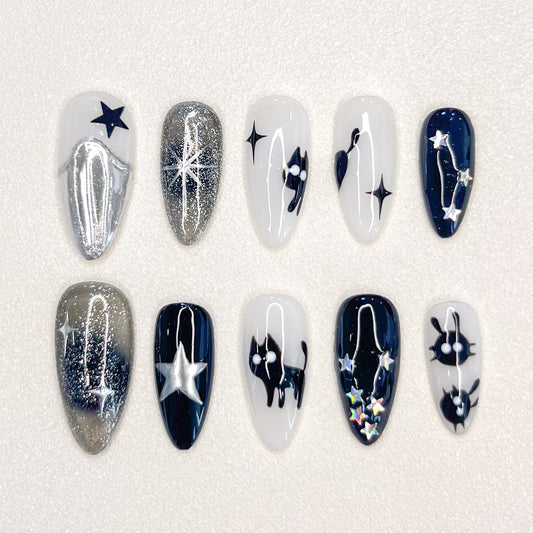 Cosmic Whispers press-on nails with star and constellation details in black, silver, and white for a celestial and dreamy look.