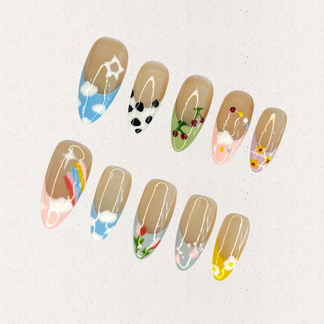 Meadow Whispers nail set showcases soft pastel colors with intricate floral and botanical patterns, evoking the tranquility and beauty of a serene meadow.