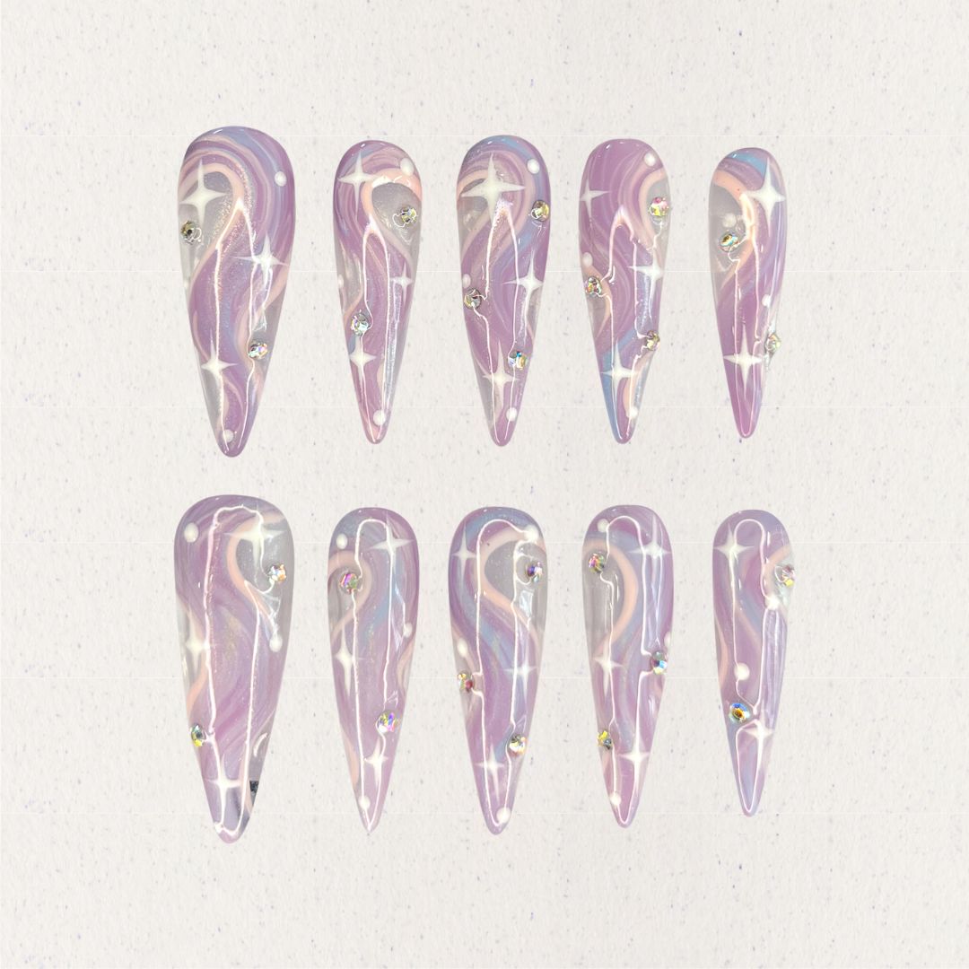 Galactic Glow nail set includes a black and silver base with bright star-like patterns and shimmering accents, delivering a galactic and futuristic aesthetic.