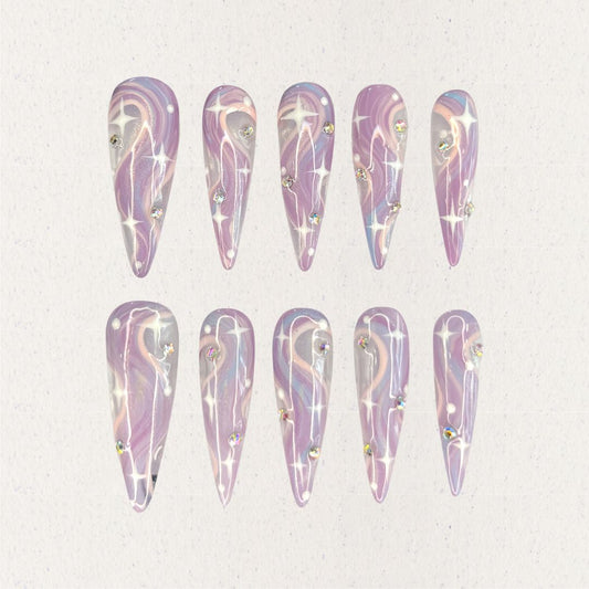 Galactic Glow nail set includes a black and silver base with bright star-like patterns and shimmering accents, delivering a galactic and futuristic aesthetic.