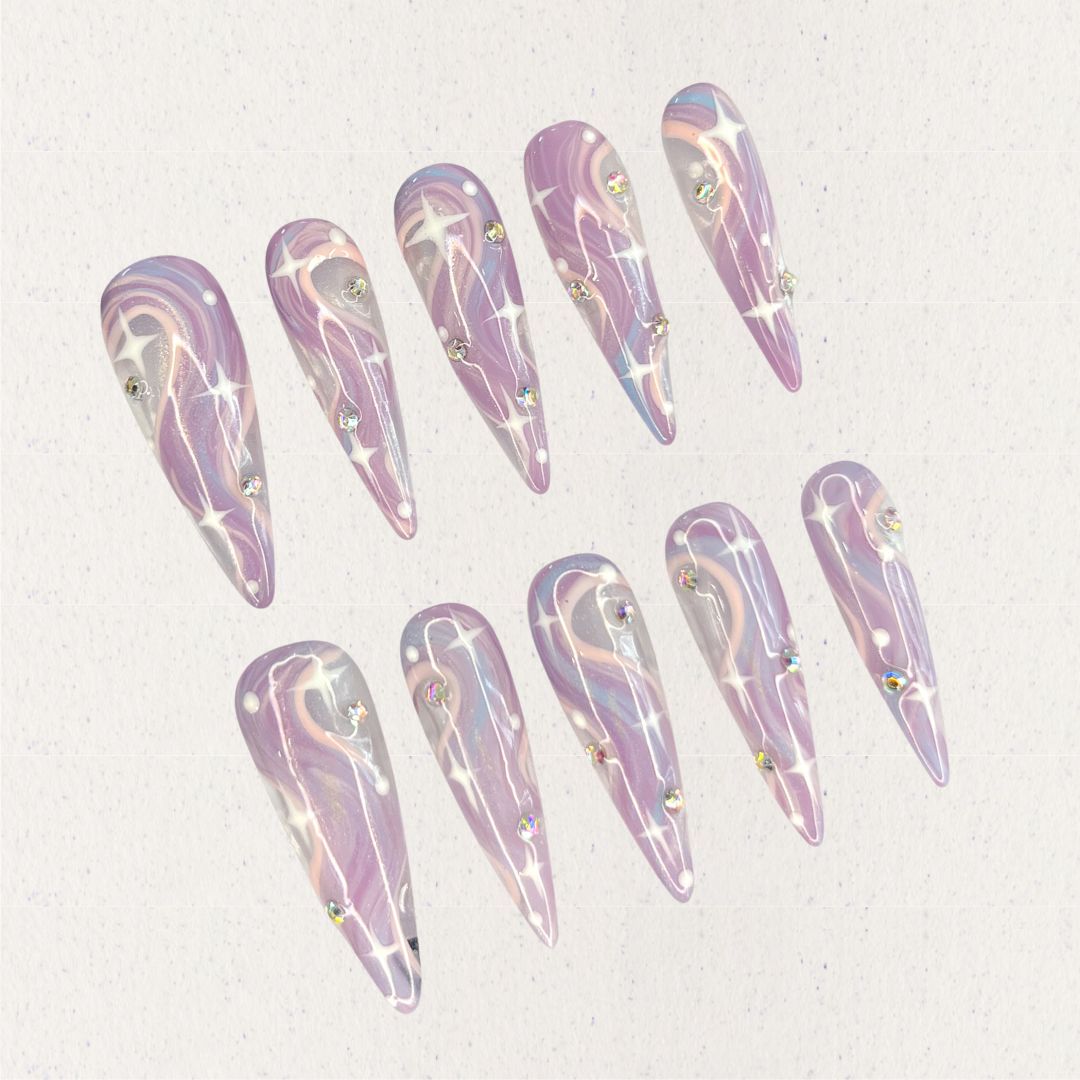 Galactic Glow nail set includes a black and silver base with bright star-like patterns and shimmering accents, delivering a galactic and futuristic aesthetic.