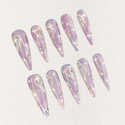 Galactic Glow nail set includes a black and silver base with bright star-like patterns and shimmering accents, delivering a galactic and futuristic aesthetic.