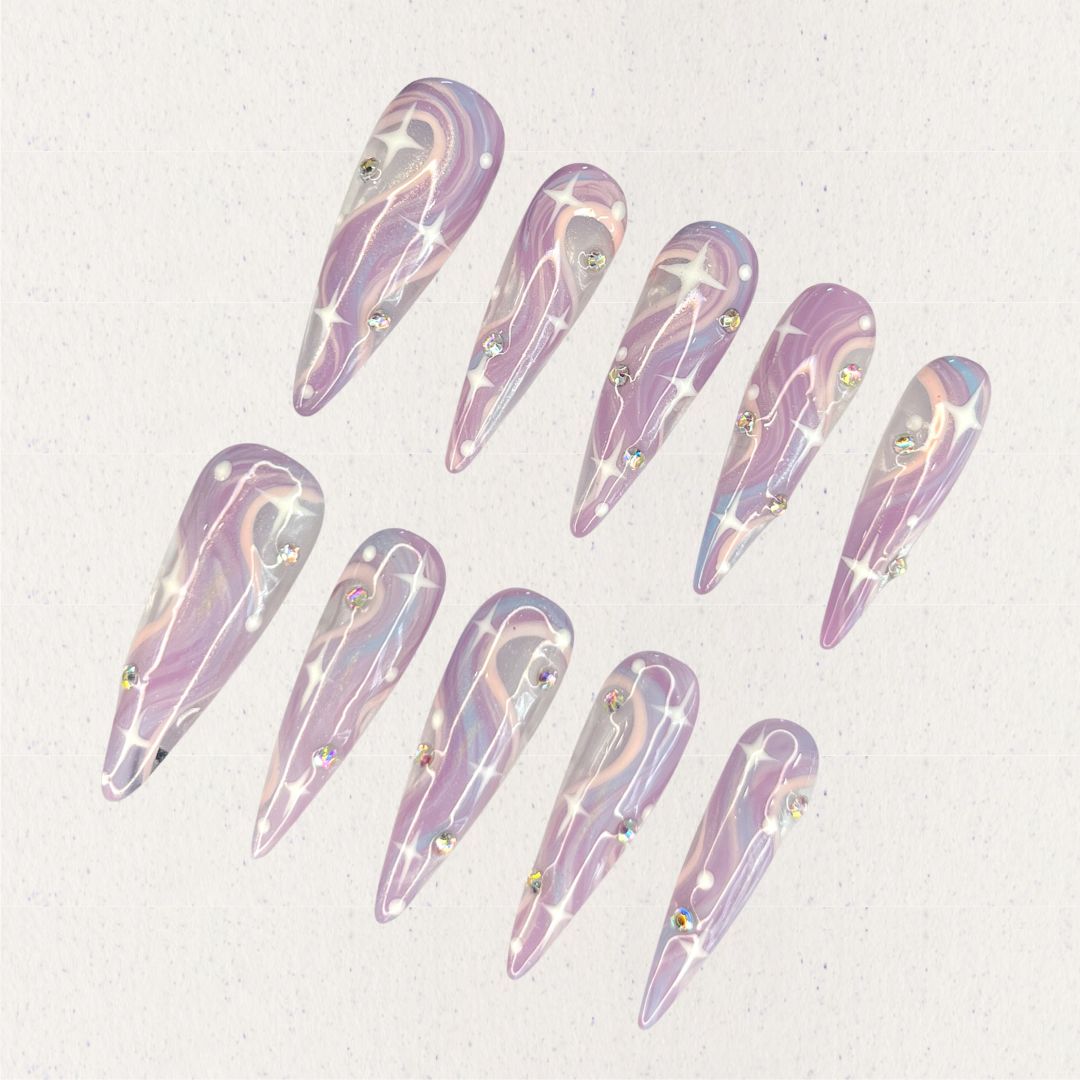 Galactic Glow nail set includes a black and silver base with bright star-like patterns and shimmering accents, delivering a galactic and futuristic aesthetic.