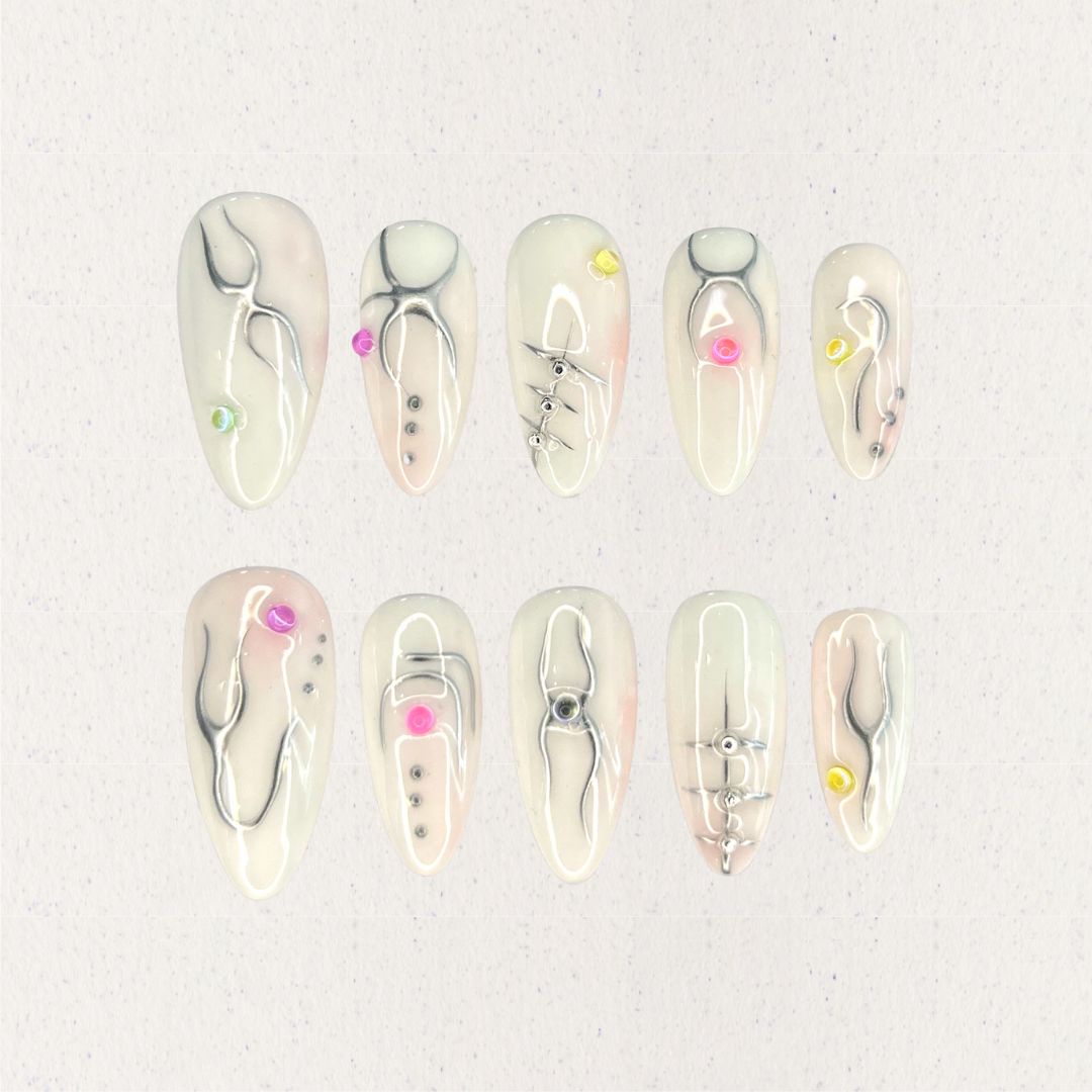 Crystal Blossom nail set features soft pastel shades adorned with hand-painted floral patterns and crystal details, evoking the charm of a blooming garden.