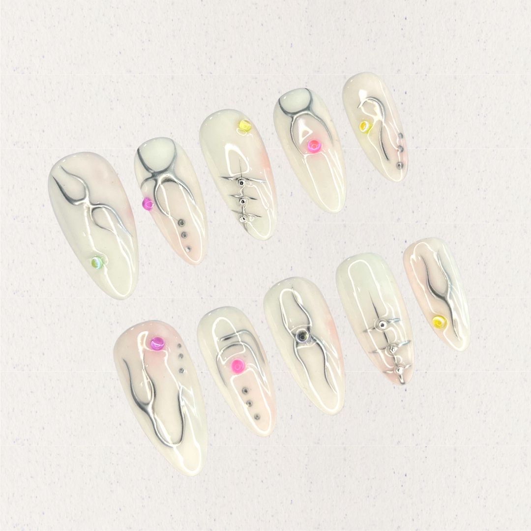 Crystal Blossom nail set features soft pastel shades adorned with hand-painted floral patterns and crystal details, evoking the charm of a blooming garden.