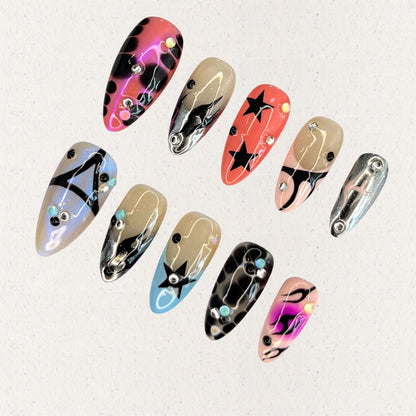 Galactic Vibes nail set showcases neon gradients with black accents, star patterns, and holographic details, exuding a dynamic and otherworldly charm.