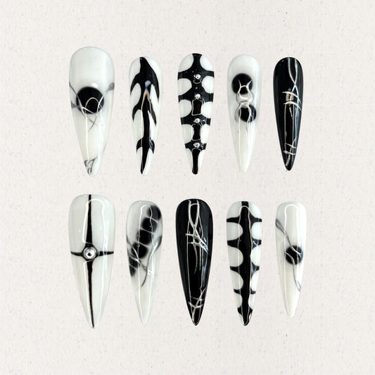 Monochrome Harmony nail set features a sharp black-and-white palette with geometric and abstract patterns, creating a timeless, high-contrast look.