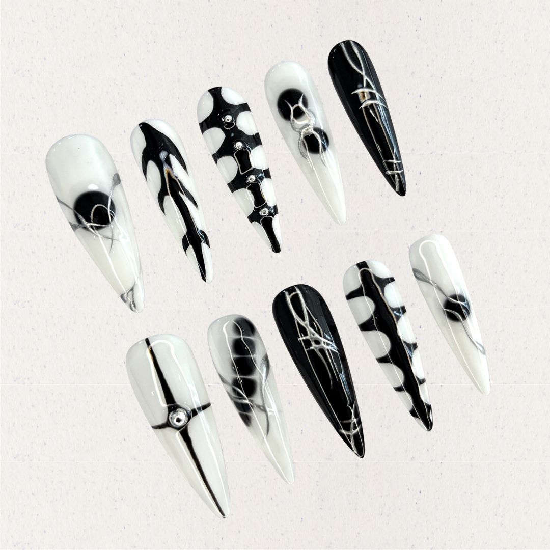 Monochrome Harmony nail set features a sharp black-and-white palette with geometric and abstract patterns, creating a timeless, high-contrast look.