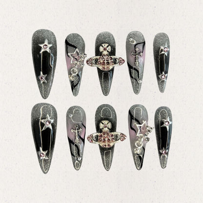 Celestial Voyage nail set features a shimmering gray base with celestial elements like stars and planets, adorned with intricate metallic and gemstone accents for a galactic aesthetic.