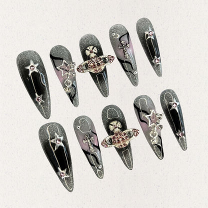 Celestial Voyage nail set features a shimmering gray base with celestial elements like stars and planets, adorned with intricate metallic and gemstone accents for a galactic aesthetic.