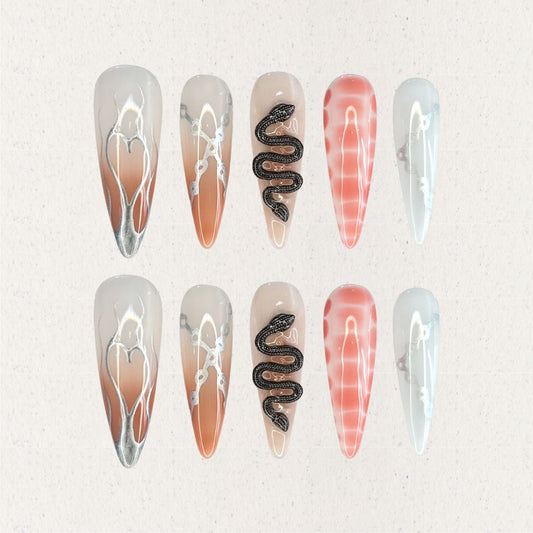 Serpent Elegance nail set includes silver snake accents, soft gradient colors, and fine line details, creating a dramatic and enchanting aesthetic.