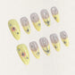 Lemon Gleam press-on nails with a soft gradient of yellow and nude shades, decorated with intricate silver linework and radiant starburst details, adding a touch of elegance and charm to your style.
