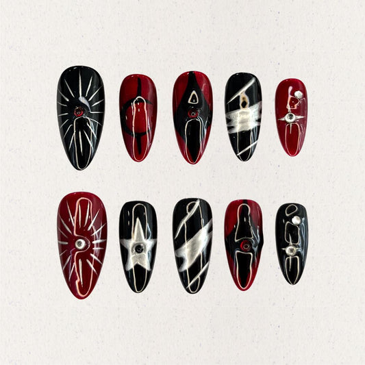 Crimson Eclipse nail set showcases a mix of black and red tones with silver highlights, celestial star designs, and geometric elements, perfect for a striking and dramatic look.