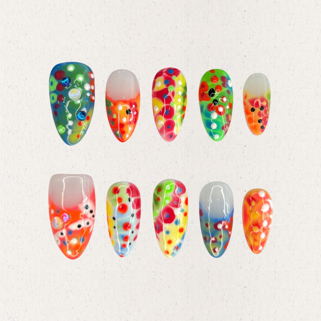 Neon Mirage nails are a vivid display of neon colors with layered dots and abstract patterns, perfect for a lively and energetic vibe.