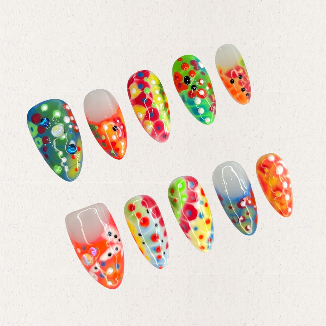 Neon Mirage nails are a vivid display of neon colors with layered dots and abstract patterns, perfect for a lively and energetic vibe.