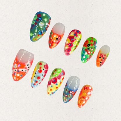 Neon Mirage nails are a vivid display of neon colors with layered dots and abstract patterns, perfect for a lively and energetic vibe.