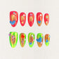 Solar Flares nail set features fiery red and neon green gradients with shimmering golden undertones, accented by 3D hearts and bubble-like embellishments. This vibrant design mirrors the dynamic beauty of solar eruptions and cosmic energy.