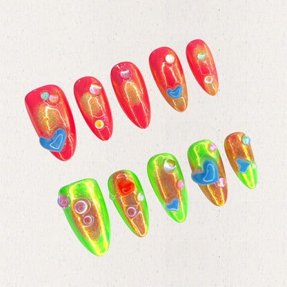 Solar Flares nail set features fiery red and neon green gradients with shimmering golden undertones, accented by 3D hearts and bubble-like embellishments. This vibrant design mirrors the dynamic beauty of solar eruptions and cosmic energy.