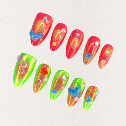 Solar Flares nail set features fiery red and neon green gradients with shimmering golden undertones, accented by 3D hearts and bubble-like embellishments. This vibrant design mirrors the dynamic beauty of solar eruptions and cosmic energy.