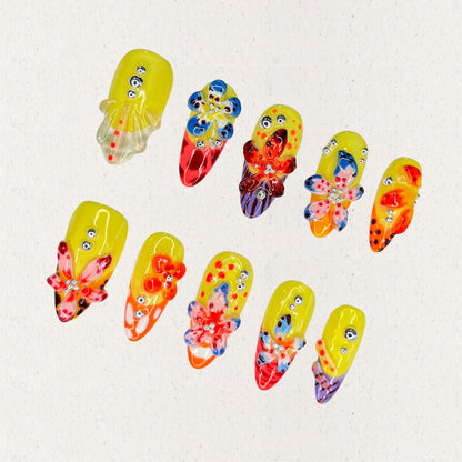 Blooming Fiesta nail set features a bright yellow base with vivid 3D flowers and rhinestones, creating a bold and celebratory floral design.