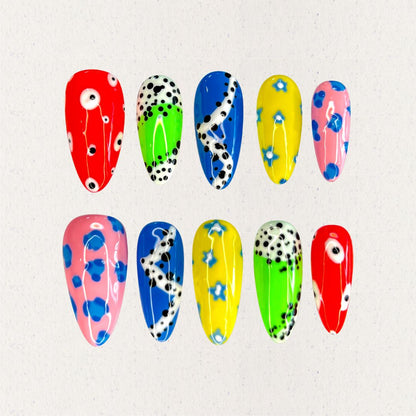 Galaxy Polka nail set takes inspiration from the playful and scattered look of a meteor shower, with bold colors like red, blue, and yellow adorned with polka dots and abstract celestial swirls. A lively design that feels like a colorful journey through the stars.