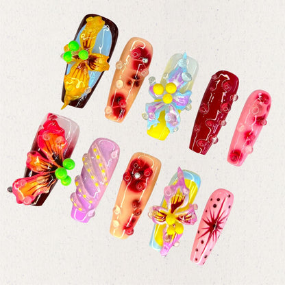 Orchid Symphony nail set is a tribute to the exotic allure of orchids, combining deep reds, soft purples, and golden yellows with realistic 3D flower details. This vibrant design embodies the grace and sophistication of these elegant blooms.