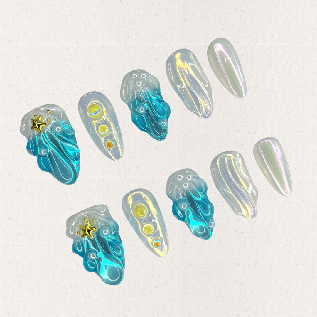 This set of press-on nails, titled "Celestial Waves," features flowing ocean-inspired blue patterns, accented by iridescent pearl white and golden star embellishments. Each nail has a distinct design, including wave-like swirls, translucent gradients, and metallic highlights. The combination creates a serene, celestial look with a minimalist and artistic feel.