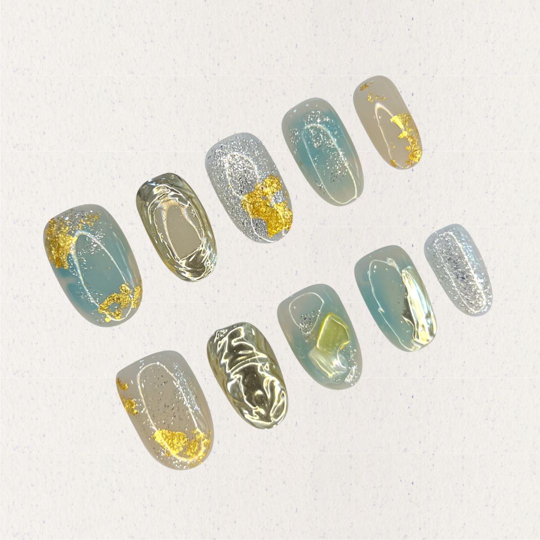 Golden Veil nail set features gold foil highlights on pastel blue and gray bases, adding an elegant shimmer and refined depth to each nail.