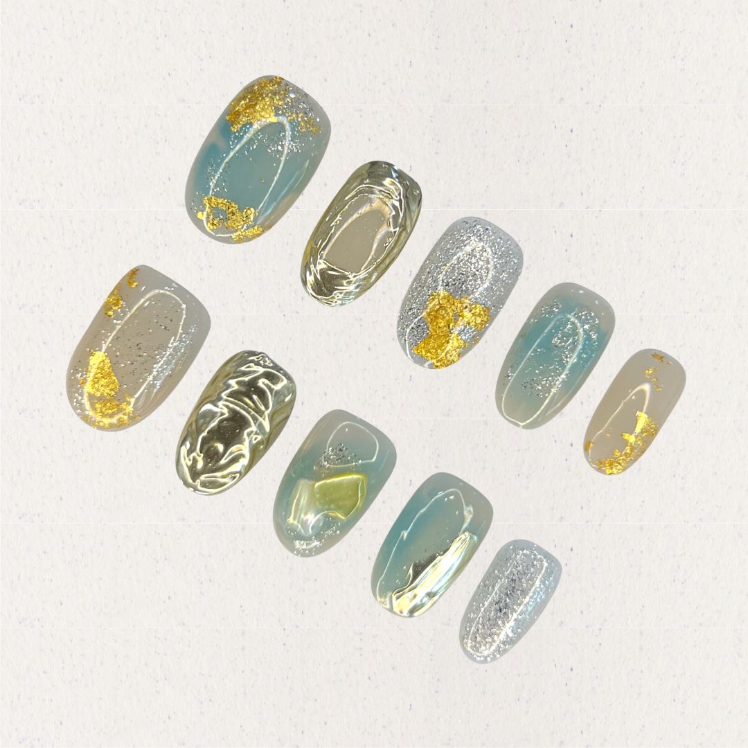 Golden Veil nail set features gold foil highlights on pastel blue and gray bases, adding an elegant shimmer and refined depth to each nail.