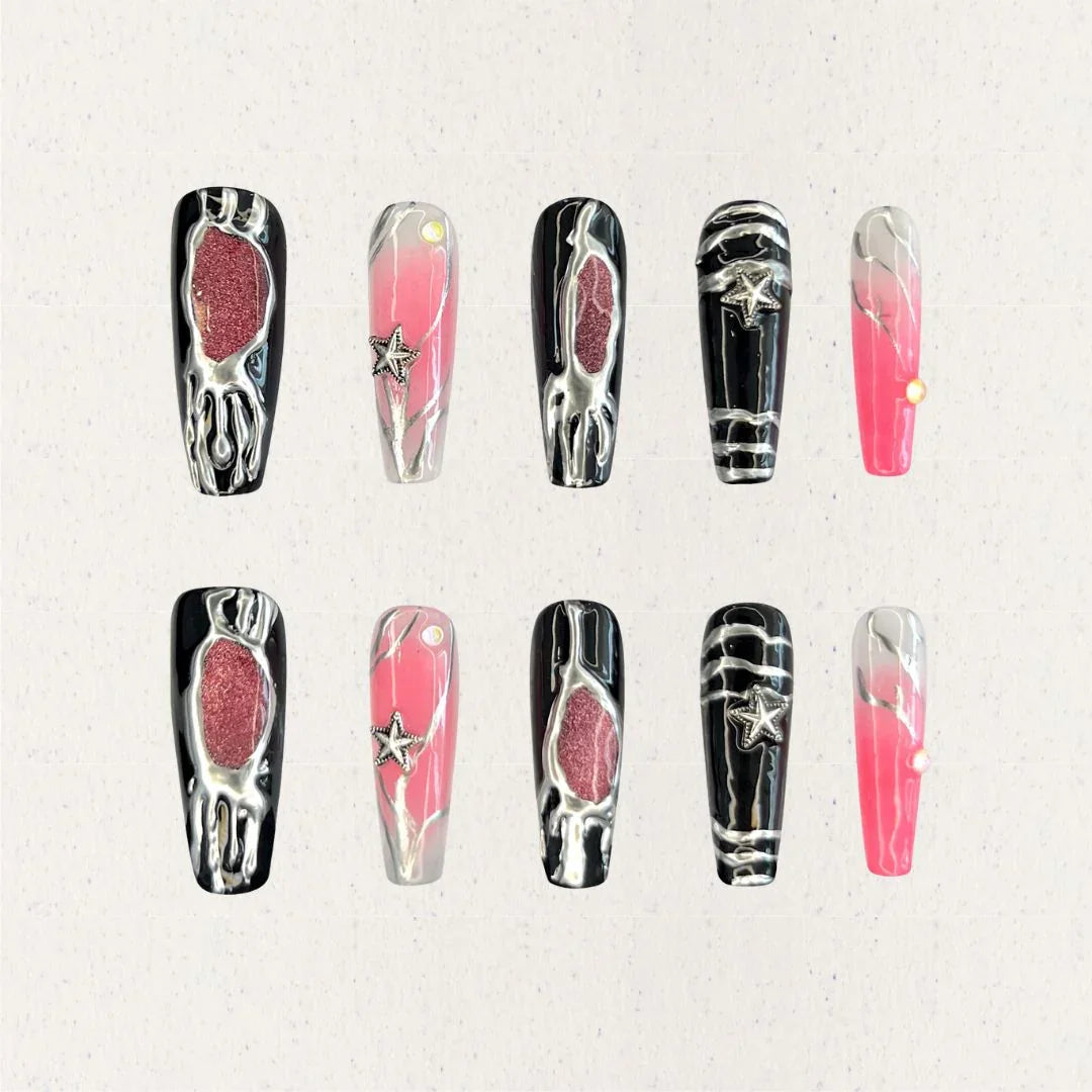 Celestial Veil nail set features dramatic black and pink gradients, accented with metallic textures and silver star embellishments. This design evokes the elegance of a starlit galaxy, wrapped in an enigmatic cosmic veil.