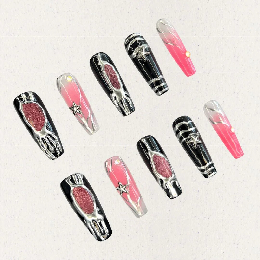 Celestial Veil nail set features dramatic black and pink gradients, accented with metallic textures and silver star embellishments. This design evokes the elegance of a starlit galaxy, wrapped in an enigmatic cosmic veil.