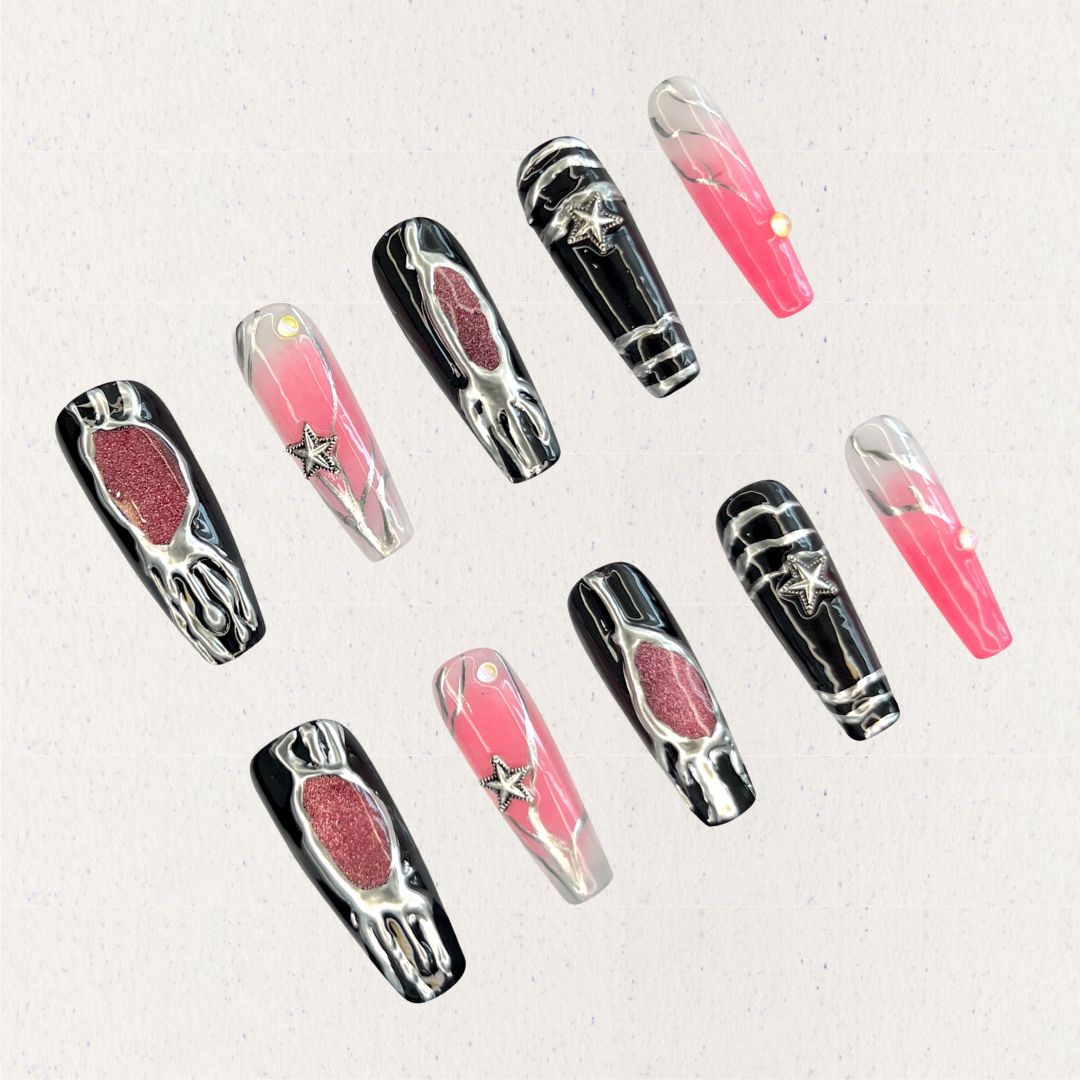 Celestial Veil nail set features dramatic black and pink gradients, accented with metallic textures and silver star embellishments. This design evokes the elegance of a starlit galaxy, wrapped in an enigmatic cosmic veil.