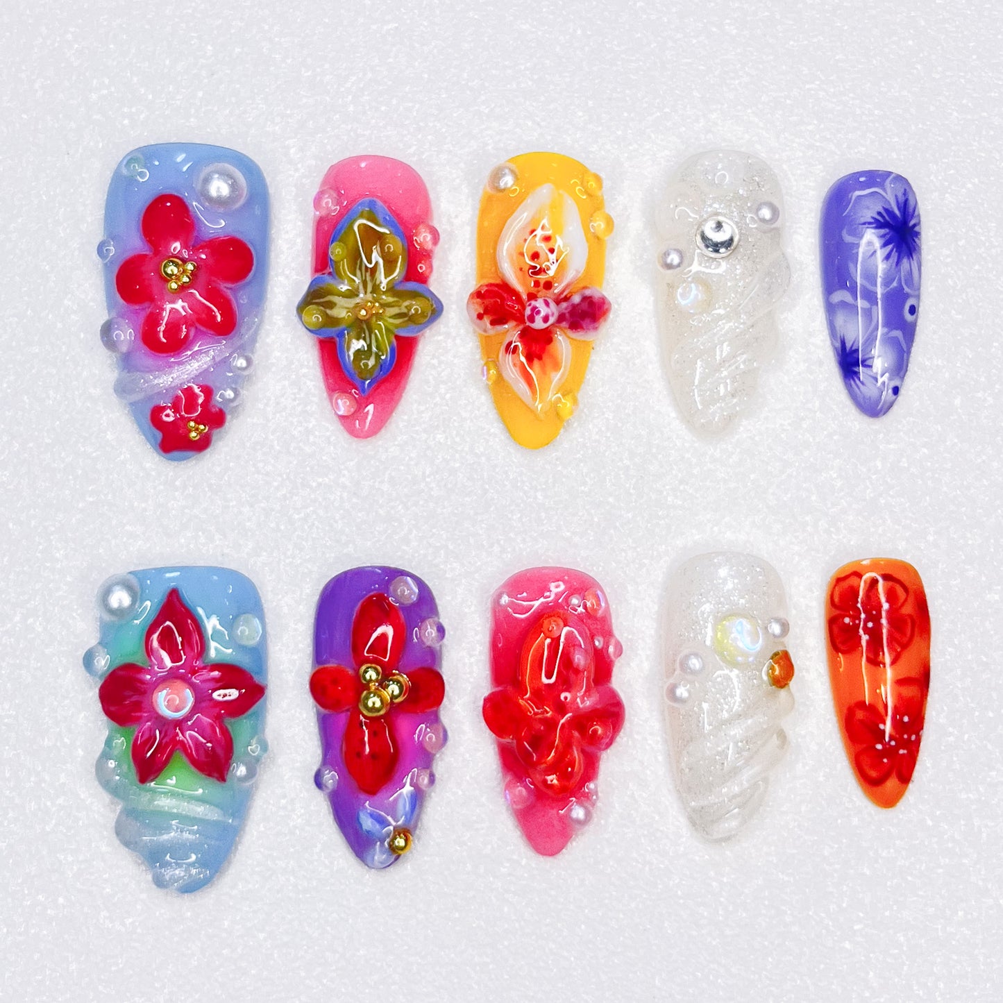 This 3D nail set, Tropical Blossom, captures the beauty of blooming flowers in bright, tropical shades. Each nail features unique floral accents with delicate details and shimmering finishes, making it an ideal choice for those seeking a lively, exotic look.