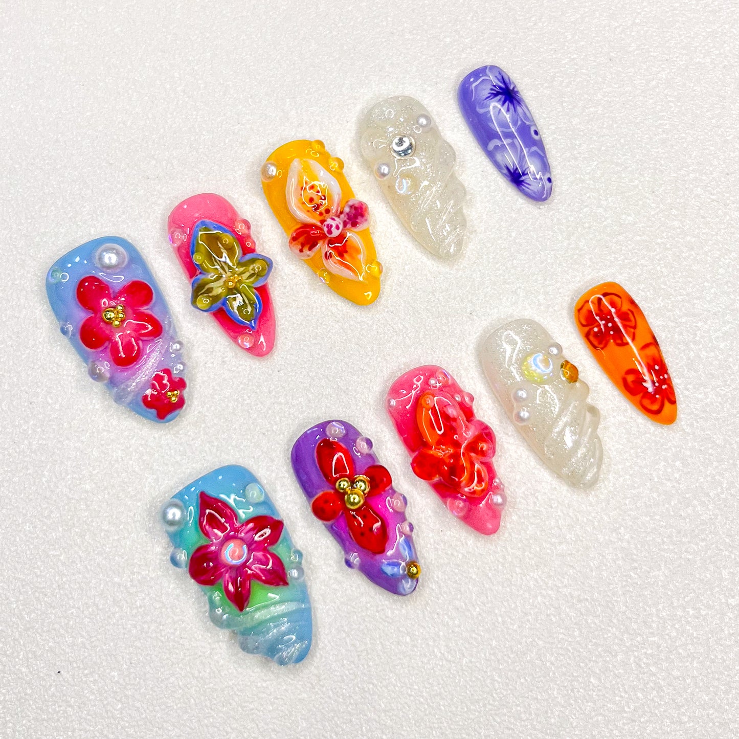 This 3D nail set, Tropical Blossom, captures the beauty of blooming flowers in bright, tropical shades. Each nail features unique floral accents with delicate details and shimmering finishes, making it an ideal choice for those seeking a lively, exotic look.