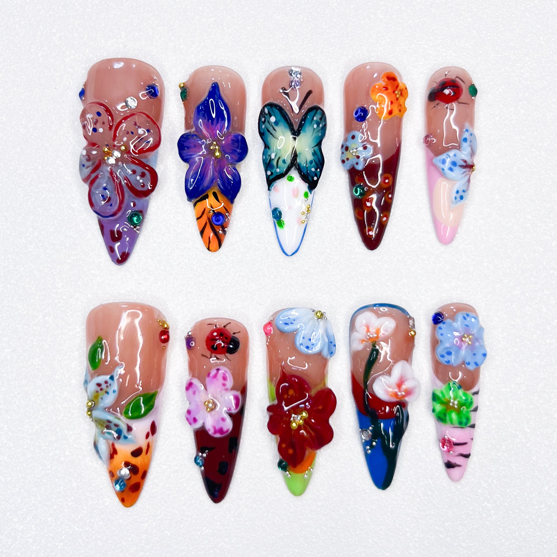 The Blossom Oasis nail set showcases beautiful, detailed 3D flowers and butterflies in a spectrum of vivid colors. Each nail exudes the lushness of a blooming garden, combining artistry with elegance. Ideal for nature lovers and those looking to add a splash of color to their look.