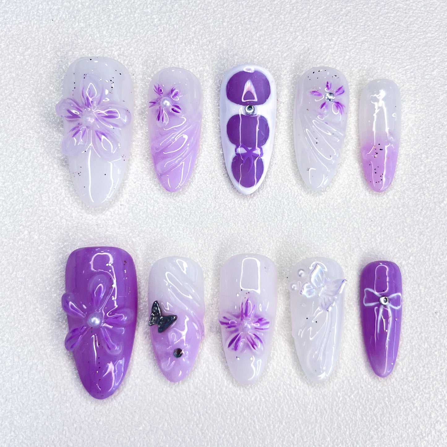 A set of press-on nails featuring purple floral designs, bringing a graceful, blooming look for a delicate and sophisticated style.