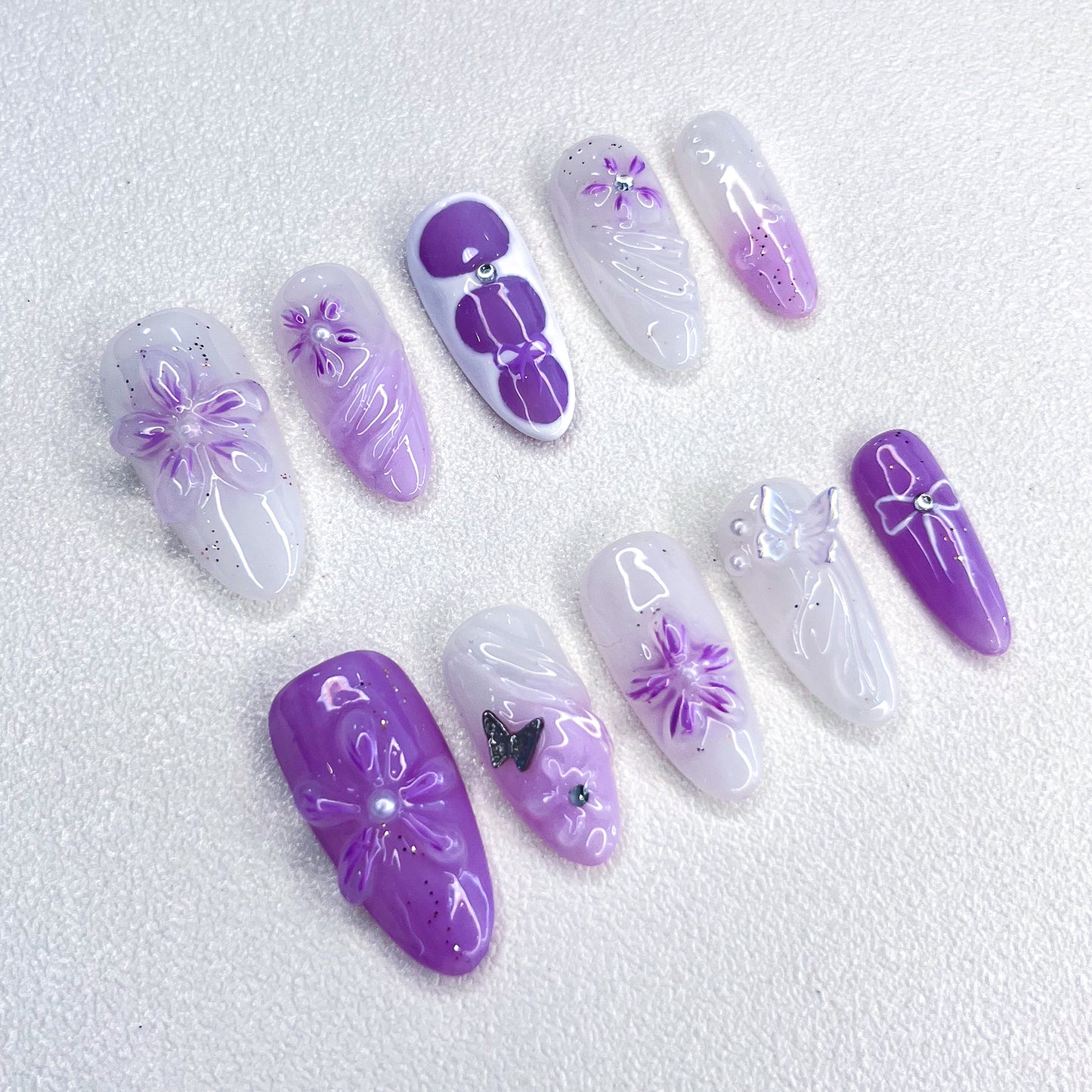 A set of press-on nails featuring purple floral designs, bringing a graceful, blooming look for a delicate and sophisticated style.