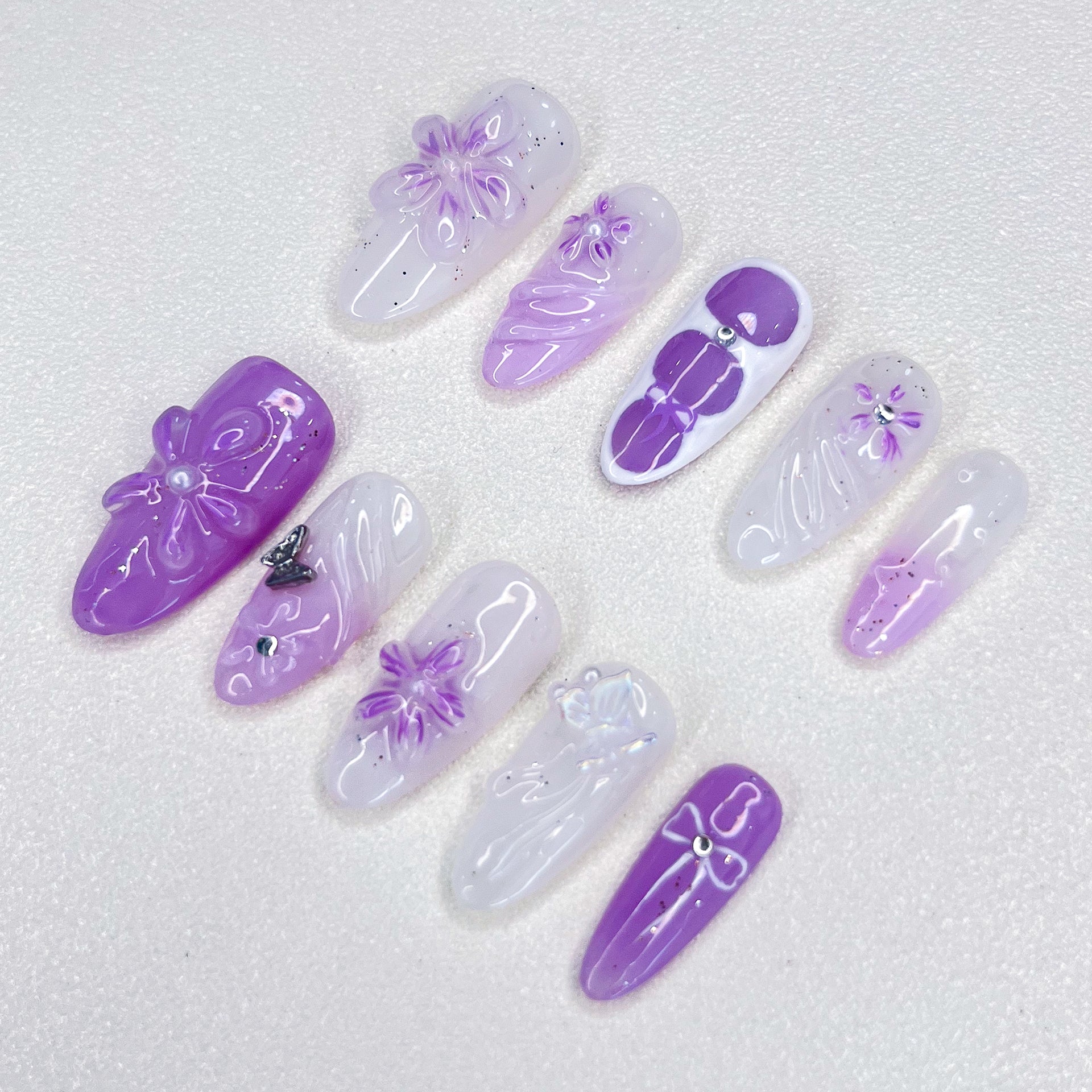 A set of press-on nails featuring purple floral designs, bringing a graceful, blooming look for a delicate and sophisticated style.