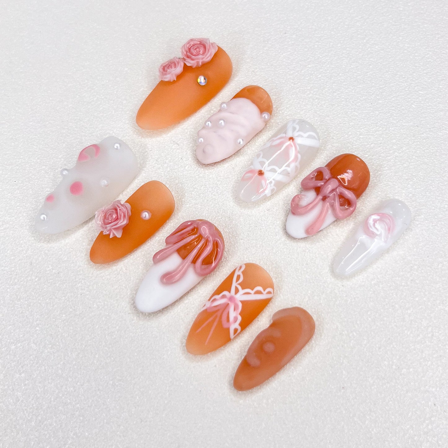 A vibrant set of press-on nails featuring bold orange designs, capturing the warmth and glow of a sunset for a bold, radiant style.