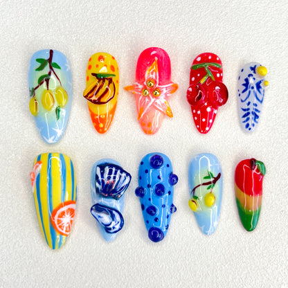 A lively set of press-on nails featuring vibrant fruit designs like lemons, bananas, and strawberries, capturing the essence of a tropical paradise in a fun, colorful style.