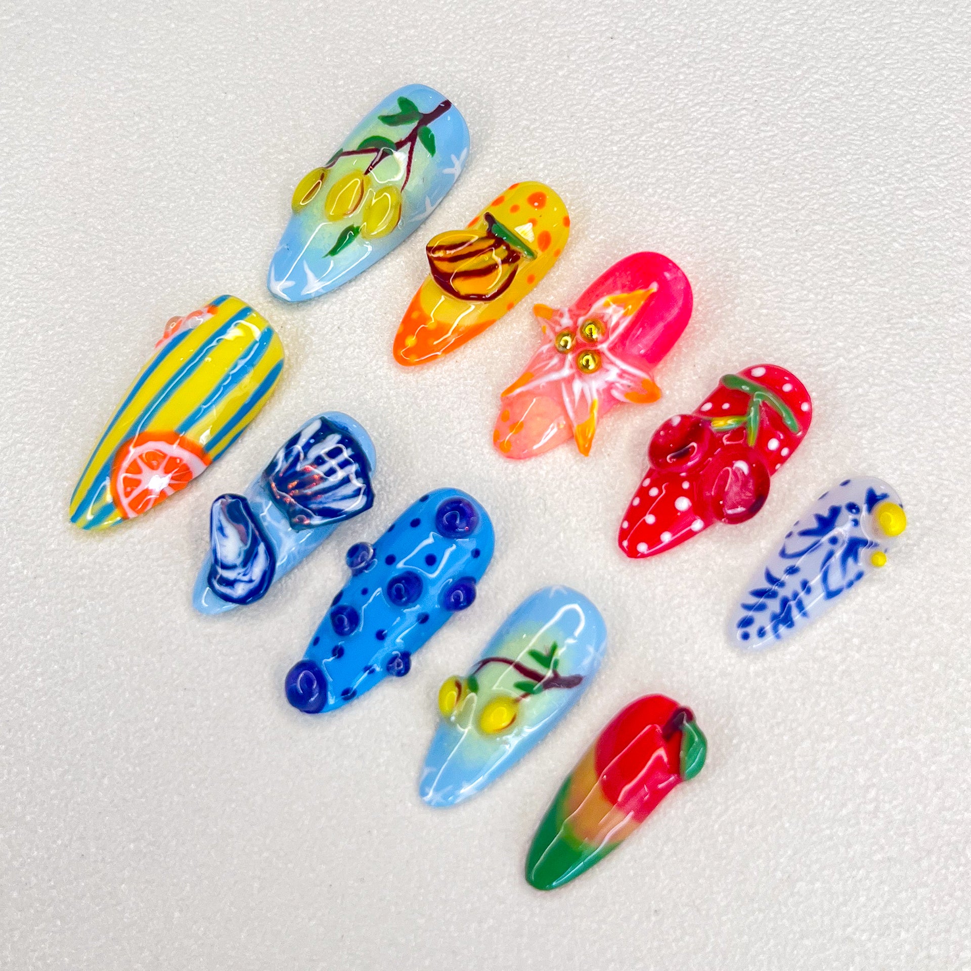 A lively set of press-on nails featuring vibrant fruit designs like lemons, bananas, and strawberries, capturing the essence of a tropical paradise in a fun, colorful style.