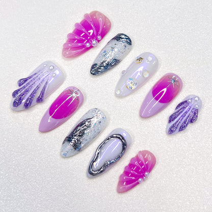 A colorful press-on nail set with purple, rose pink, and blue tones, adorned with seashells and wave designs, bringing a dreamy, mermaid-inspired charm to your style.